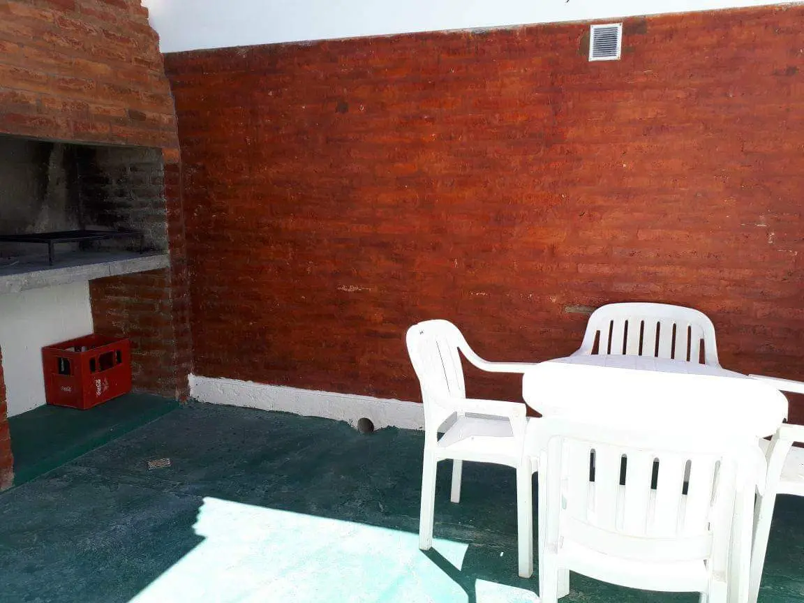 Patio con parrilla de ladrillo, mesa y sillas